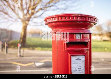 SWANSEA, UK - 25. FEBRUAR 2021: Klassischer Vintage roter britischer Pfeiler-Kasten, freistehender Briefkasten für Briefe in einer Straße in Wales, Vereinigtes Königreich Stockfoto