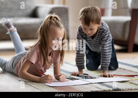 Zwei niedliche Geschwister Vorschulkinder Zeichnung in Papier-Alben Stockfoto