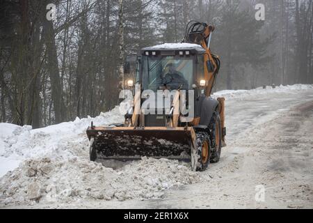 Russland. Vyborg 02.27.2020 EIN Mann auf einem Traktor entfernt Schnee von den Straßen der Stadt. Hochwertige Fotos Stockfoto