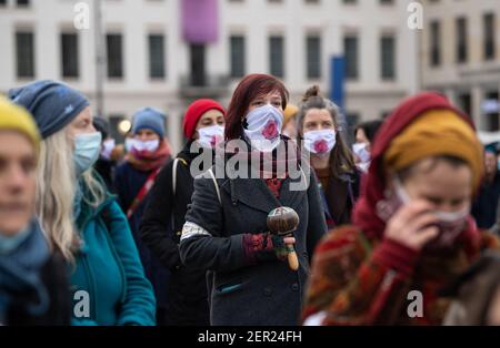 Berlin, Deutschland. Februar 2021, 28th. Teilnehmer des "multikulturellen Frauenmarsches für Freiheit, Toleranz und die Zukunft unserer Kinder" stehen am Pariser Platz. Viele von ihnen tragen Mund- und Nasenschutz mit einer Zeichnung der Yoni Rose. Nach tantrischen Lehren steht es für die weiblichen Genitalien Credit: Paul Zinken/dpa-Zentralbild/dpa/Alamy Live News Stockfoto