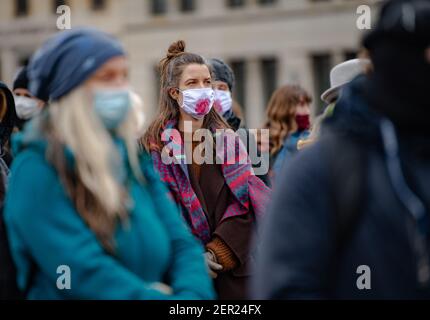 Berlin, Deutschland. Februar 2021, 28th. Teilnehmer des "multikulturellen Frauenmarsches für Freiheit, Toleranz und die Zukunft unserer Kinder" stehen am Pariser Platz. Viele von ihnen tragen Mund- und Nasenschutz mit einer Zeichnung der Yoni Rose. Nach tantrischen Lehren steht es für die weiblichen Genitalien Credit: Paul Zinken/dpa-Zentralbild/dpa/Alamy Live News Stockfoto