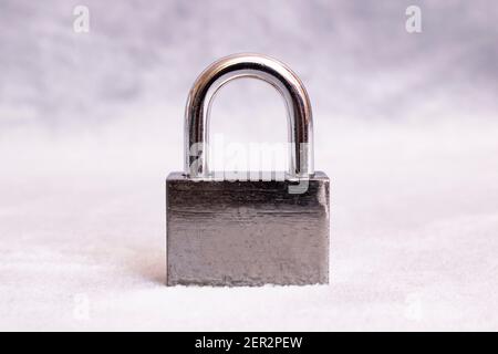 Metallvorhängeschloss und Schlüssel auf grauem Hintergrund Stockfoto