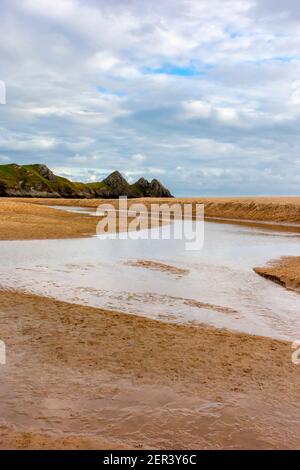 Pennard pill ein Bach, der über den Sandstrand fließt Bei Three Cliffs Bay an der Südküste der Gower Peninsula in der Nähe von Swansea in Südwales Großbritannien Stockfoto