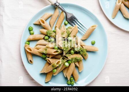 Vollkorn-Penne mit grünen Erbsen und Pesto. Stockfoto