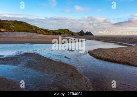 Pennard pill ein Bach, der über den Sandstrand fließt Bei Three Cliffs Bay an der Südküste der Gower Peninsula in der Nähe von Swansea in Südwales Großbritannien Stockfoto