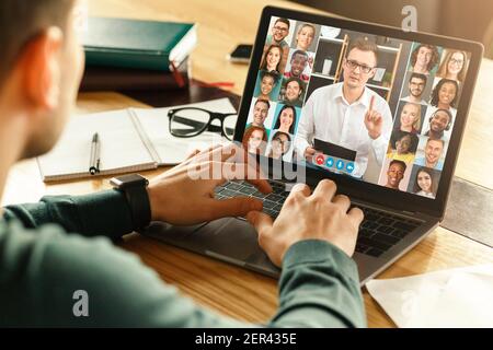 Rückansicht des männlichen Mitarbeiters mit Videokonferenz auf Laptop Mit Kollegen Stockfoto