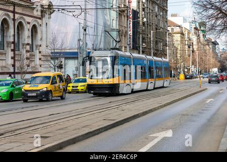 Sofia, Bulgarien - 28. Februar 2021: Eine Straßenbahn fährt vor Halite. Markthalle im Zentrum von Sofia, der Hauptstadt von Bulgarien, auf Mari gelegen Stockfoto