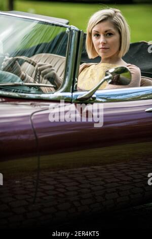 Modische Frau mit dem Luxus-Cabriolet 1966 Jaguar S1 4.2 Roadster in East Sussex, England. Stockfoto