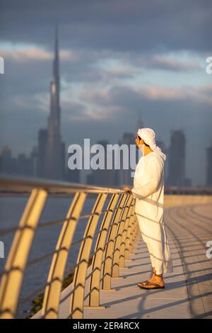 emirati man in Al Jaddaf Waterfront in Dubai mit Burj Khalifa im Hintergrund Stockfoto