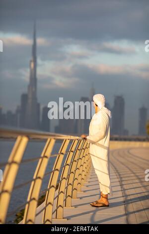 emirati man in Al Jaddaf Waterfront in Dubai mit Burj Khalifa im Hintergrund Stockfoto