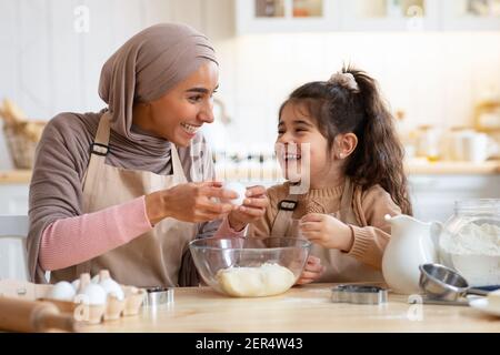 Familientraditionen. Happy Muslim Mutter Und Kleine Tochter Spaß Beim Backen Stockfoto