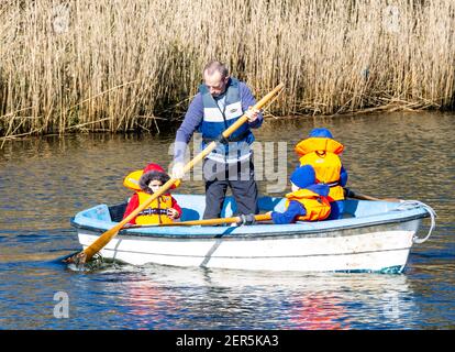 Vater und drei Kinder Boot auf See. Stockfoto