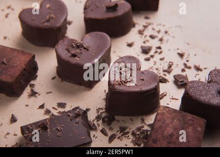 Zwei handgemachte Schokoladenherzen auf handwerklichen Hintergrund mit Chips. Valentine s Konzept Stockfoto