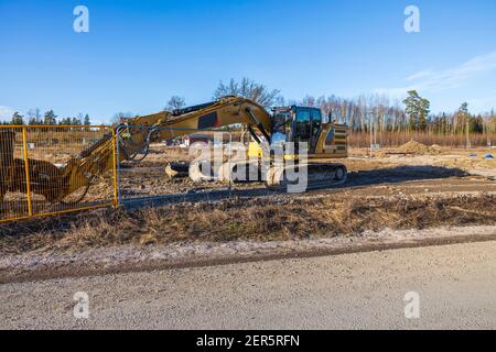 Nahaufnahme des Baubaggers auf Außenbaustelle auf frühlingsblauem Himmel Hintergrund. Stockfoto