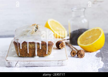 Zitronenkuchen mit Mohnsamen, bedeckt mit Glasur auf hellem Hintergrund. Stockfoto