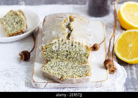 Zitronenkuchen mit Mohnsamen, bedeckt mit Glasur auf hellem Hintergrund. Stockfoto