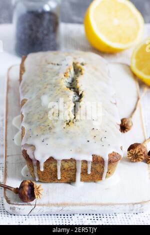 Zitronenkuchen mit Mohnsamen, bedeckt mit Glasur auf hellem Hintergrund. Stockfoto