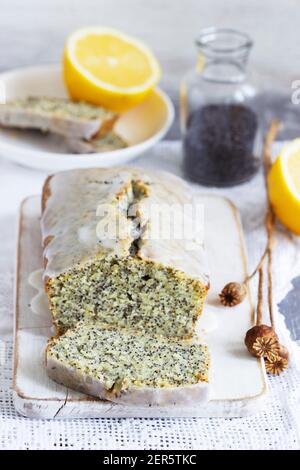 Zitronenkuchen mit Mohnsamen, bedeckt mit Glasur auf hellem Hintergrund. Stockfoto