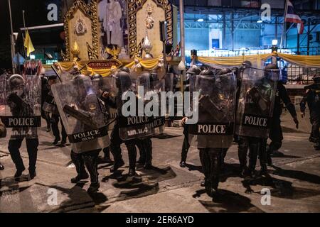 Neben einem Porträt des thailändischen Königs Maha Vajiralongkorn während einer Anti-Regierungsdemonstration in Bangkok stehen die Bereitschaftspolizisten hinter ihren Schilden.Tausende von prodemokratischen Demonstranten versammelten sich in der Vibhavadi Rangsit Road vor dem Infanterie-Regiment 1st in der Nähe des Premierministers und forderten den Rücktritt des thailändischen Premierministers und Die Reform der Monarchie in Bangkok, Thailand. Die Demonstranten verurteilten auch die Anwendung des ‘Lese majeste Gesetz' unter dem Abschnitt 112 des Strafgesetzbuches. Der von ‘FreeYouth' organisierte Protest endete mit mehreren Zusammenstößen, dem Einsatz von Wasserwerfern, Tränengas Stockfoto