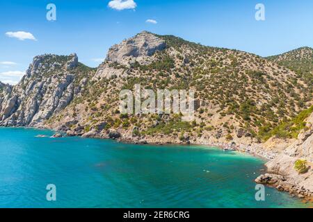 Kap Kapchik. Sommer Krimlandschaft mit Touristen am Strand. Schwarzmeerküste an einem sonnigen Tag, Novyi Svit, Sudak Gemeinde, Krim Stockfoto