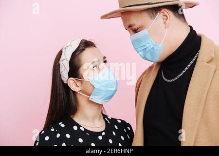 Ein Mann und eine Frau sehen sich an, sie tragen medizinische Schutzmasken. Hochwertige Fotos Stockfoto