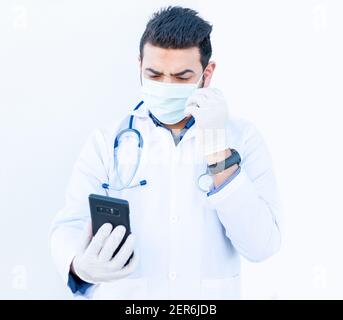 Arabischer Arzt, der sein Smartphone benutzt, um medizinische Dinge zu besprechen Online Stockfoto