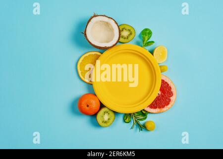 Zusammensetzung von Zitrusfrüchten, Orange und Zitrone, Kokosnuss, Kiwi auf zyanischem Hintergrund Stockfoto