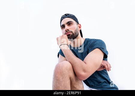 Kerl auf seinem Knie sitzen und etwas beobachten Stockfoto