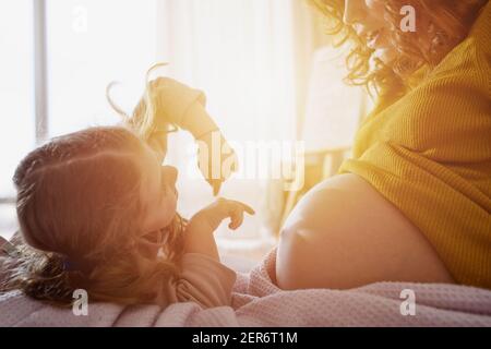 Schwangere Mutter spielt mit ihrer Tochter. Familienkonzept, Freude und Schwangerschaft Stockfoto