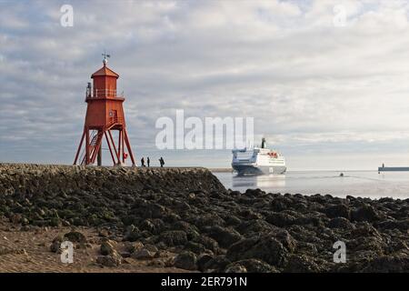 Die leuchtend rot bemalte Herde Groyne Lighhouse steht in der Mündung des Flusses Tyne in Littlehaven, South Shields in Tyne und tragen. Stockfoto