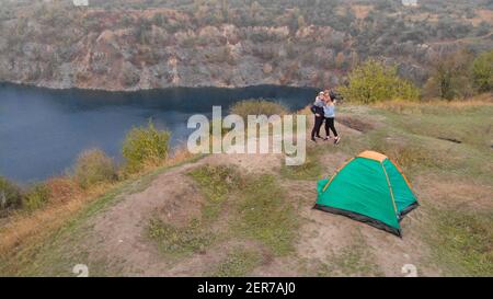 Luftaufnahme der Familie auf dem Campingplatz von oben, Eltern und Kind entspannen und Spaß haben in der Nähe Berge See, Familiencamp Urlaubskonzept Stockfoto