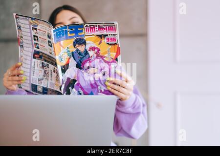 Junge Frau liest Manga-Comic zu Hause. Stockfoto