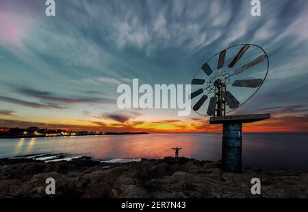 Wunderschöne Aussicht auf eine große Windmühle über Sonnenuntergang Himmel Hintergrund an der Küste. Anfeh. Libanon Stockfoto