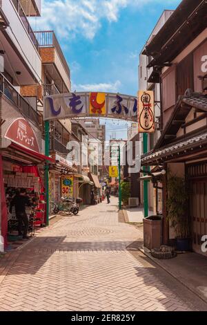 tokio, japan - april 07 2019: Metallischer Bogen mit dem Maskottchen Shiichan und dem Namen der Shimofuri Einkaufsstraße in Komagome mit einigen Sch geschmückt Stockfoto