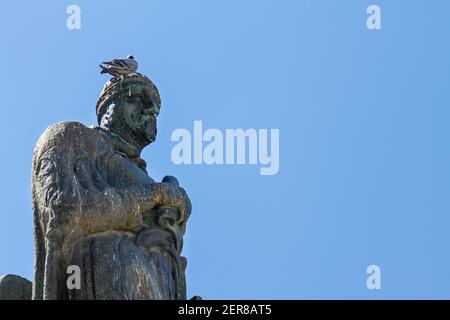 Vögel, die in städtischen Gebieten leben, verursachen erhebliche Schäden an historischen Denkmälern und Statuen. Eine mittelalterliche Ritterstatue in Tarifa ist mit unansehnlichen bedeckt Stockfoto