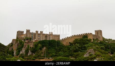 Obidos, Portugal ist eine ummauerte Stadt mit gut erhaltenem Schloss und Mauern, die die Siedlung auf dem Hügel umgeben. Diese mittelalterlichen Steinbauten sowie Stockfoto