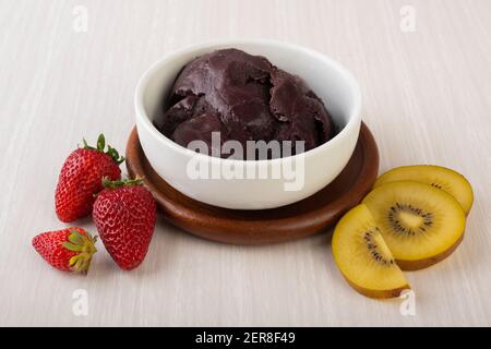 Brasilianische typisch acai Schale mit Früchten auf Holz Hintergrund. Stockfoto