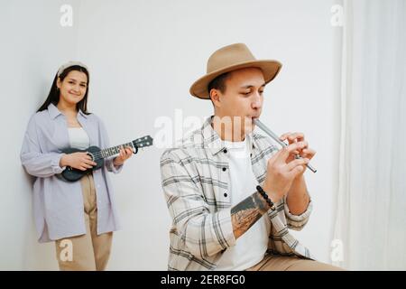 Ein Mann spielt die irische Flöte, und ein Mädchen spielt auf einer Ukulele Stockfoto