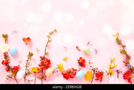 Ostereier und Frühlingsblumen auf pinkfarbenem Hintergrund Stockfoto