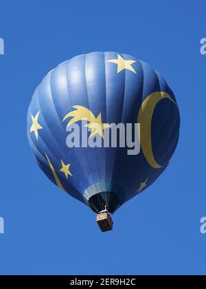 Blauer und gelber Heißluftballon vor dem Hintergrund des blauen Himmels. Low-Angle-Ansicht. Stockfoto