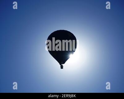 Heißluftballon silhouetted gegen die Morgensonne. Von der Seite betrachtet. Stockfoto