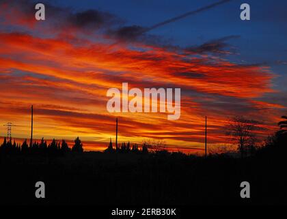 Wunderbarer Farbenfroher Sonnenuntergang Mit Beleuchteten Wolken In Rot Und Orange Auf der Baleareninsel Mallorca an EINEM sonnigen Wintertag mit Ein paar Wolken am Himmel Stockfoto