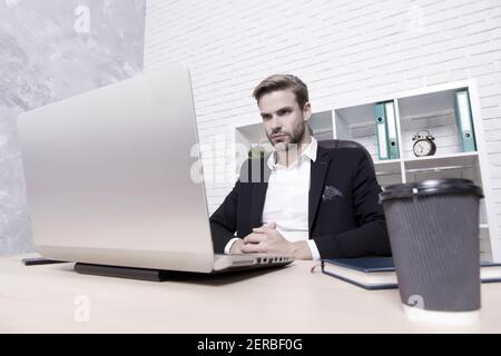 Finanzdirektorbüro. Konzentrierter Broker. Wirtschaft Rezession und Erholung. Finanzexperte Mann arbeiten mit Laptop trinken Kaffee. Börsenkonzept. Finanzielle Investitionen Kryptowährung. Stockfoto