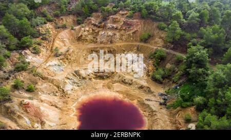 Luftaufnahme einer verlassenen Tagebaugrube in Mathiatis, Zypern. Der saure rote See ist ein Ergebnis der Pyriterz-Extraktion Stockfoto