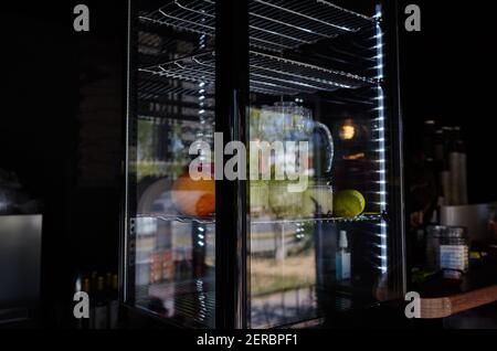 Verschwommenes Bild von Showcase im Café-Shop. Obst und Krug mit Getränk auf den Regalen eines Fensters eines Straßenrestaurants Stockfoto