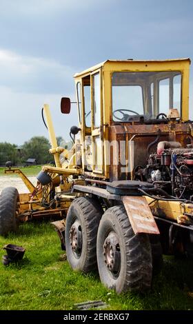 Straßengrader - Schwererde bewegende Straßenbauausrüstung. Industrieller Motorgrader auf dem Boden Stockfoto