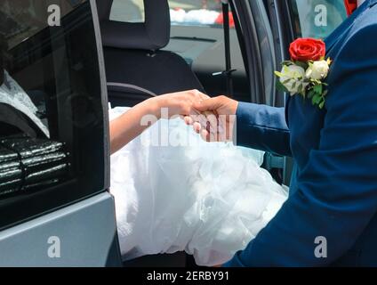 Der Bräutigam nimmt und hält die Hand seiner Braut bei der Hochzeit Nahaufnahme. Stockfoto