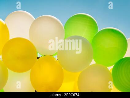 Bunte, helle Luftballons am blauen Himmel aus der Nähe. Stockfoto