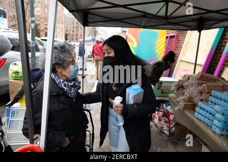 New York, New York, USA. Februar 2021, 28th. SANDRA PEREZ, links von der Quuensbridge Community spricht mit der Community Organisatorin GRACE FRUTOS während der Wiedereröffnung der Queensbridge Community Fridge auf der 40th Avenue in New York. Über 500 Pfund Nahrung, Kleidung und verderbliche Waren wurden gespendet. Frutos sagte: "Dieser neue Kühlschrank ist vegetarisch, voller Obst und Gemüse, und wir hüpfen ihn, um einen gesünderen Lebensstil und gesündere Lebensmittel für die Gemeinschaft zu fördern. "Sobald dieser Kühlschrank von der Community passend ist, hoffen wir, einen zweiten Kühlschrank zu bauen. (Bild: © Brian Branch Price/ZUMA W Stockfoto