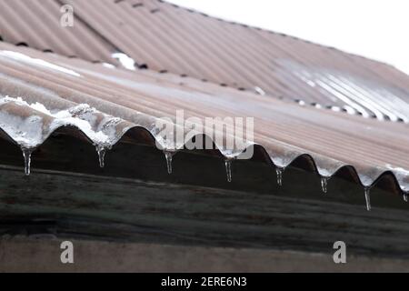 Das Dach des Gebäudes. Eiszapfen auf dem Dach. Winterfotos Stockfoto